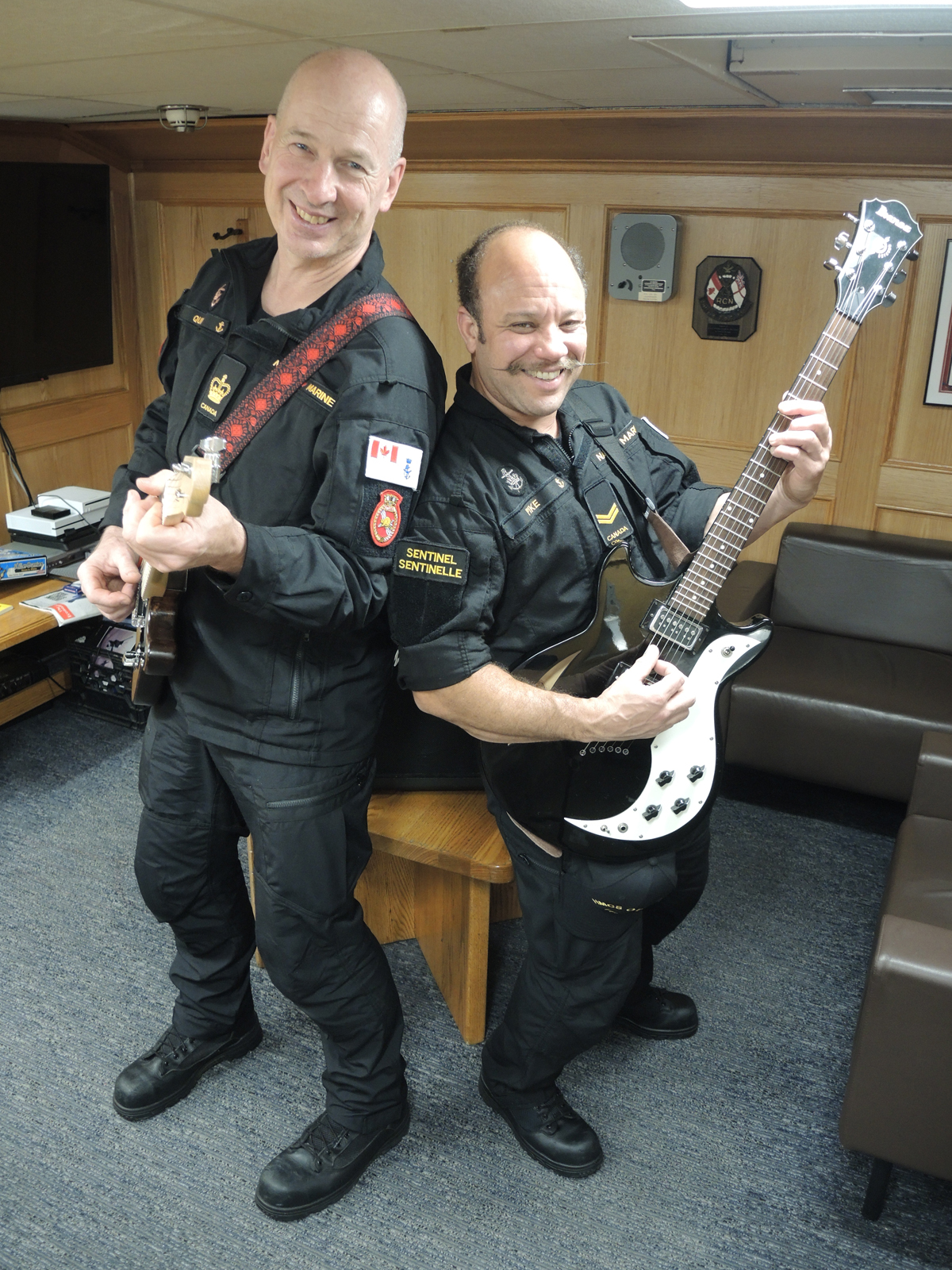 Petty Officer First Class Paul Quin and Sailor First Class Syl Pike practise playing their guitars in the Chief and Petty Officers' Mess aboard HMCS Ottawa. The two sailors have launched a program to provide musical instruments to sailors aboard ship during its upcoming deployment to the Indo-Pacific region. Photo: Peter Mallett/Lookout Newspaper.