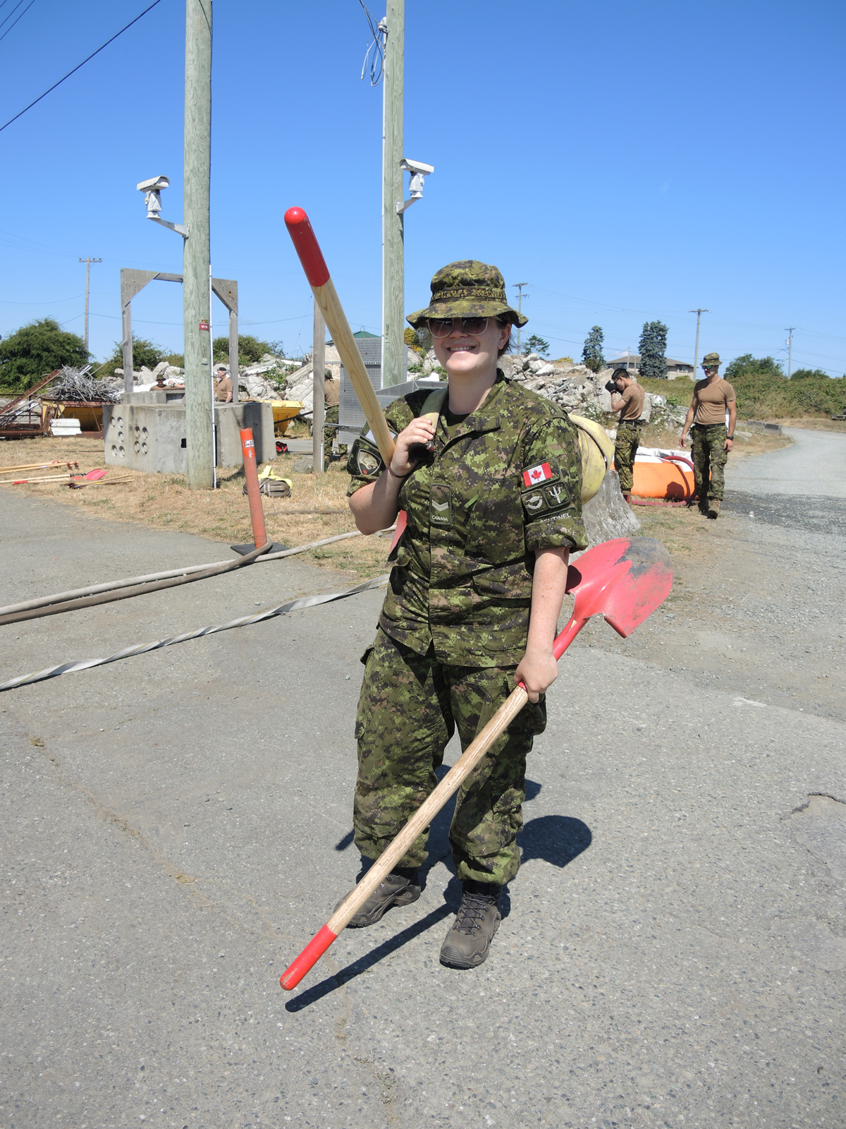 Le Caporal Kathleen Parker, réserviste de l’Armée de terre du British Columbia Regiment (Duke of Connaught’s Own), porte des pelles utilisées pour la lutte contre les feux de forêt pendant l’entraînement de l’OP Lentus, le 21 juillet au Centre d’entraînement en recherche et sauvetage en milieu urbain de la BFC Esquimalt. Les membres du 39e Groupe-brigade du Canada se déploieront ce mois-ci dans l’intérieur central de la Colombie-Britannique pour lutter contre les feux de forêt. Photos: Peter Mallett/ Journal le Lookout