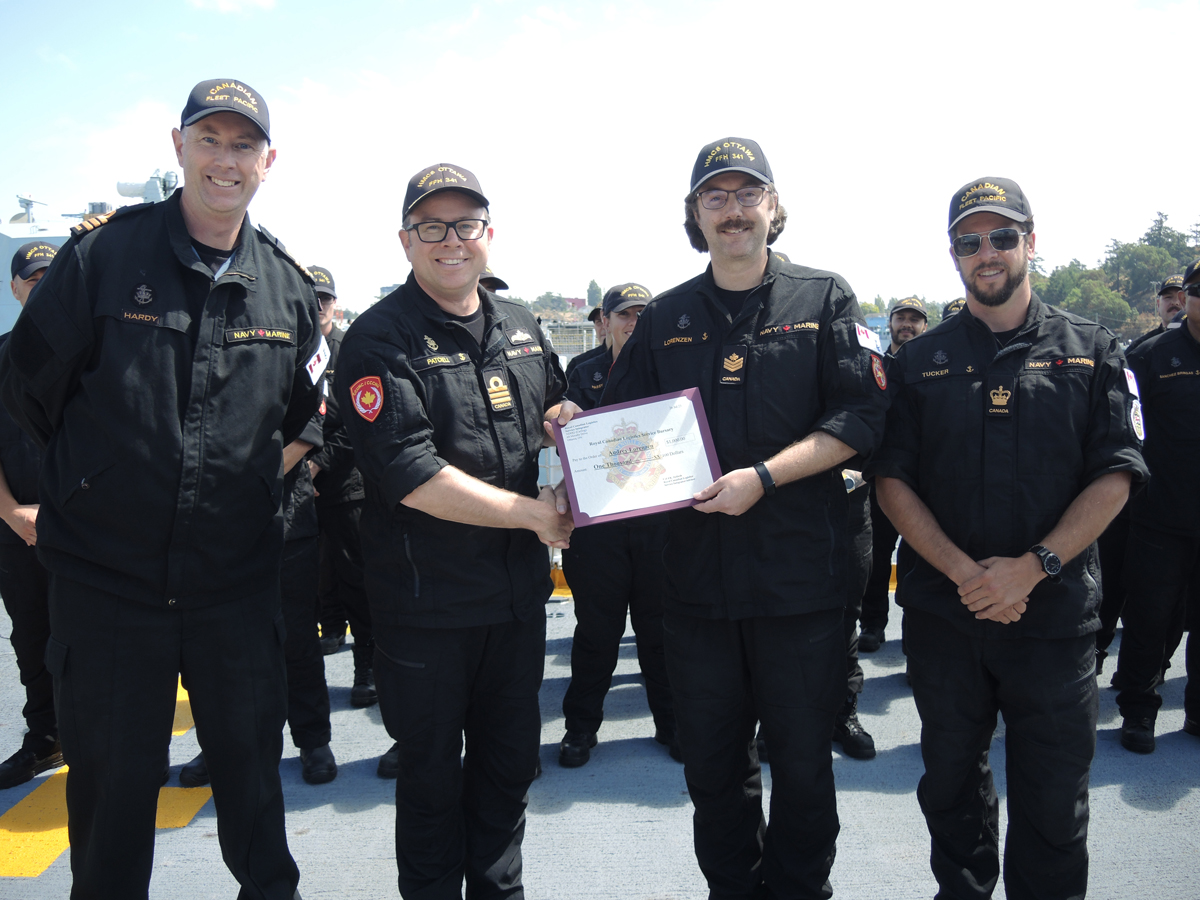 (Left) Commander (Cdr) Matthew Hardy, Fleet Logistics Officer, Cdr Sam Patchell, HMCS Ottawa Commanding Officer, and Petty Officer First Class Paul Tucker of Canadian Fleet Pacific present Petty Officer Second Class Kenneth Lorenzen with an award from the Royal Canadian Logistics Service (RCLS) Fund Bursary Program, Aug. 9 aboard HMCS Ottawa. Credit: Peter Mallett/Lookout