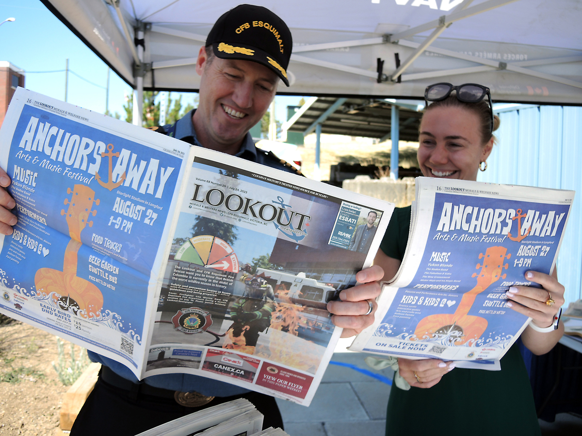 Le Capitaine de vaisseau Kevin Whiteside, commandant de la BFC Esquimalt, lit un exemplaire du journal Lookout avec Jazmin Holdway, gestionnaire de Lookout, lors du salon professionnel industriel Ship to Shore à l’aréna Wurtele, le 1er août. Photos : Peter Mallett/Lookout Newspaper