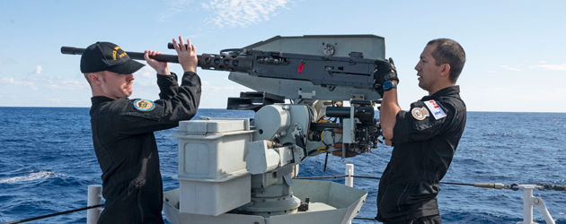 (Left to right) Sailor 3rd Class Kelley (S3) and Sailor 2nd Class (S2) Yaretz of His Majesty's Canadian Ship (HMCS) Vancouver conduct regular maintenance on the .50 calibre heavy machine gun during Exercise ANNUALEX in the Philippine Sea on 14 November 2023. Photo credit: Corporal Alisa Strelley, Canadian Armed Forces Photo.