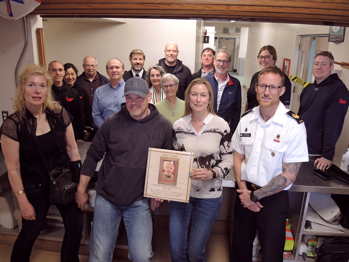 (Right) Petty Officer 2nd Class John Helpard, a Divisional Petty Officer of Naval Fleet School (Pacific), presents a plaque to Mike Hannam and Shannon Burnham, children of former PSP worker Bruce Hannam. They are joined by friends and co-workers of Bruce, who attended a memorial service in his honour at the Naden Athletic Centre, April 5. Credit: Peter Mallett