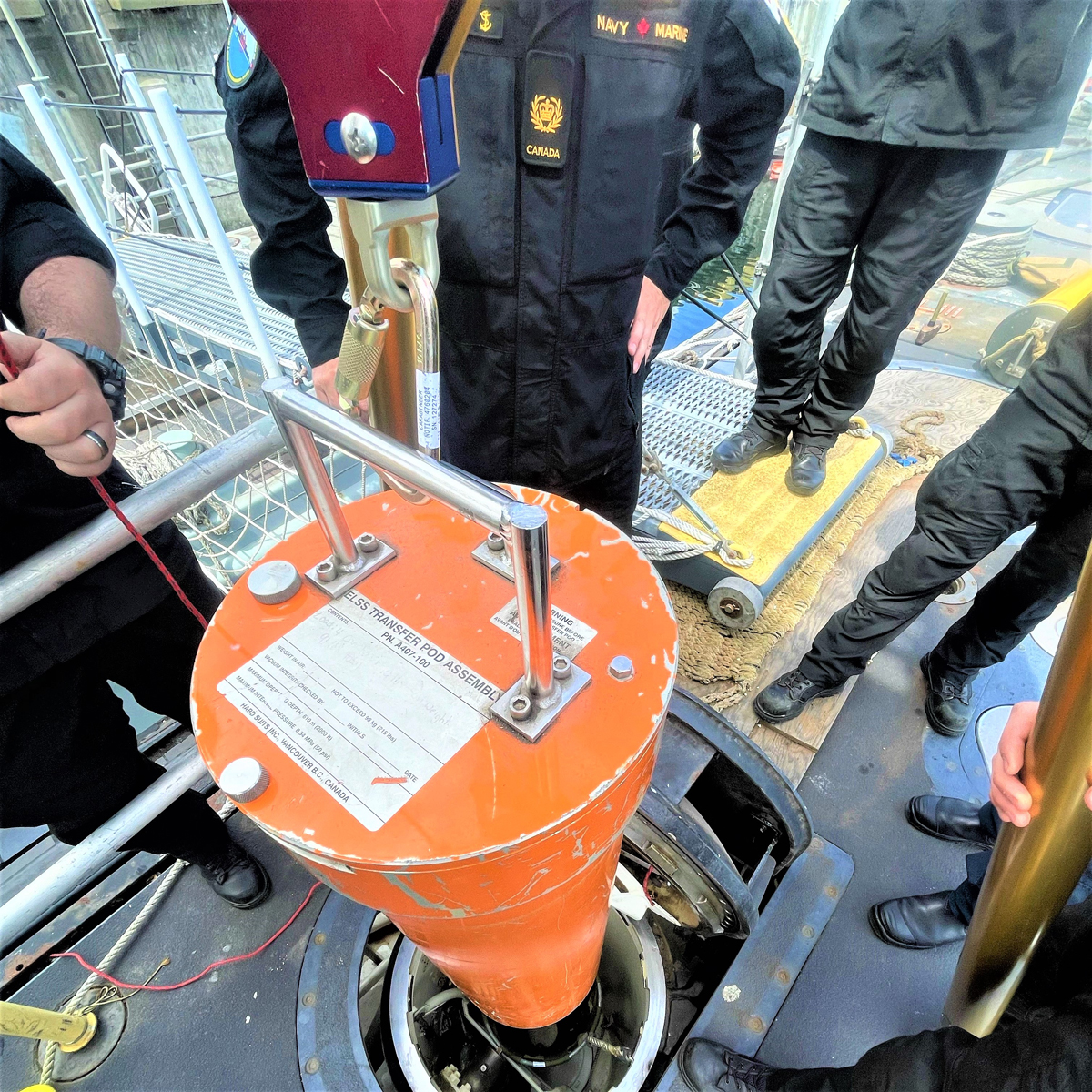 Member’s of CANSUBFOR placing the ELSS pod into the posting bag onboard HMCS Chicoutimi.