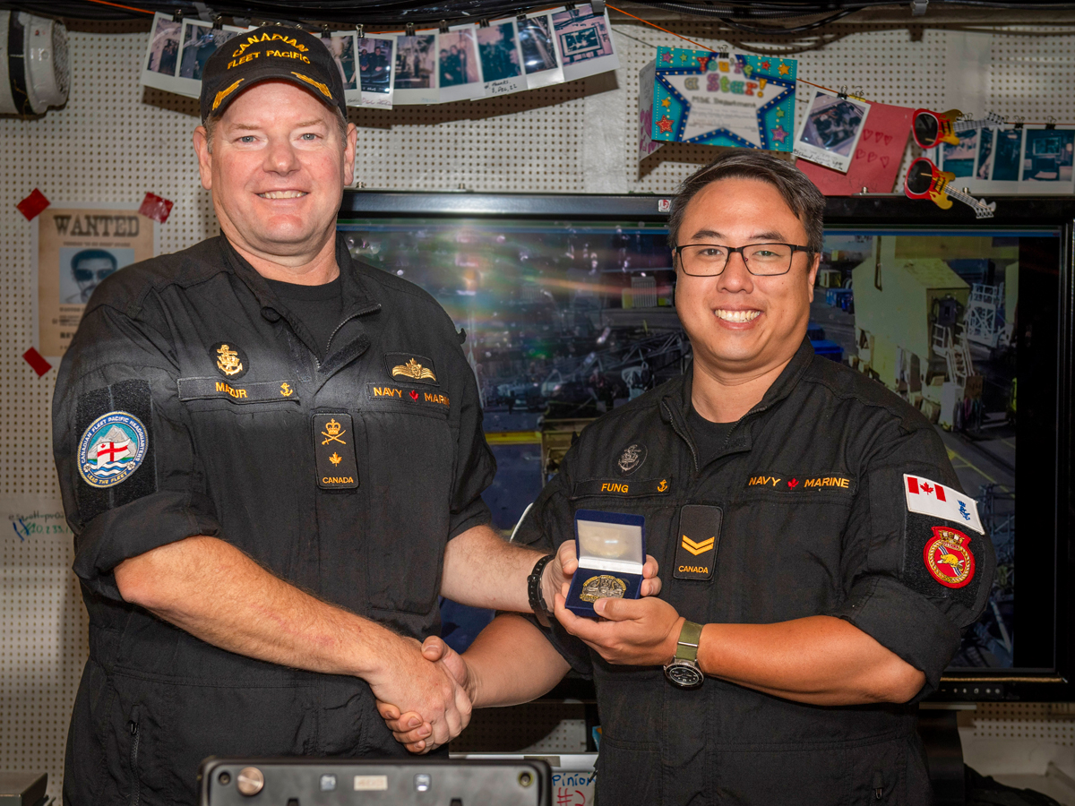 Commodore David Mazur, Commander Canadian Fleet Pacific, presents Sailor 1st Class Michael Fung with Sailor of the Quarter Coin aboard HMCS Ottawa docked at CFB Esquimalt on July 16. Photo: Sailor 3rd Class Mckayla Ryce, MARPAC Imaging Services