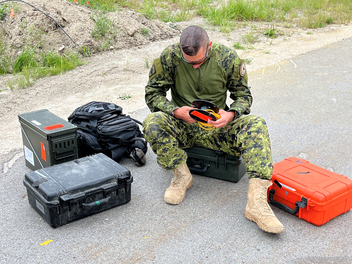 Petty Officer 2nd Class Paul Paquette in the process of reorganizing his gear after the end of their mission at the Parks Canada compound in Rogers Pass B.C.