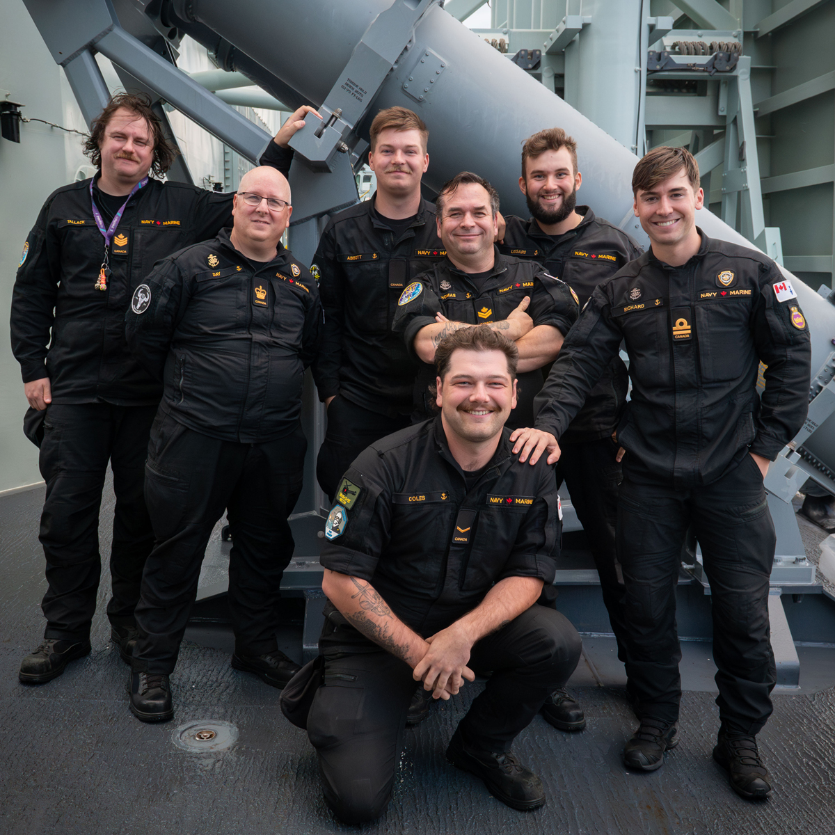 Photo de groupe des opérateurs de détecteurs électroniques navals du NCSM Regina et de l'officier superviseur, prise à côté de l'un des lanceurs de missiles Harpoon du navire, au large de la côte californienne.