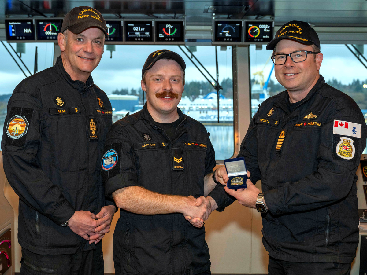 Le Mat 1 Jacob Barrett reçoit la pièce du marin du trimestre des mains du Capitaine de frégate Sam Patchell, commandant adjoint de CANFLTPAC, et du Pm 1 David Bisal, chef de la flotte, le 16 septembre.